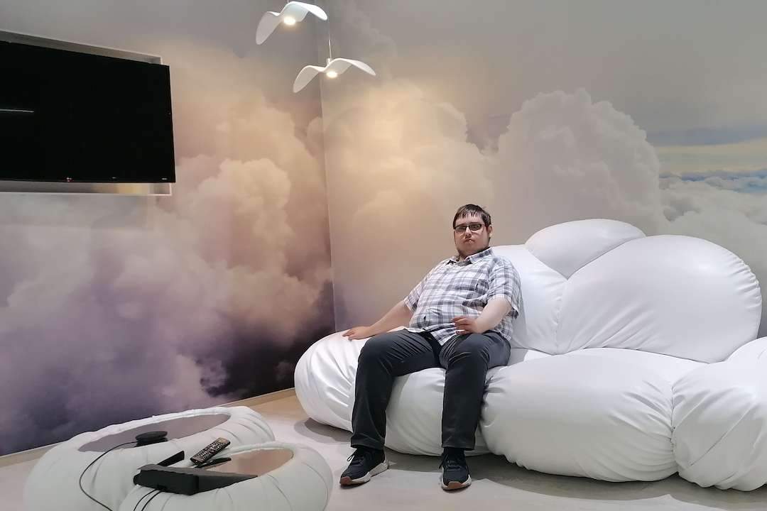Артём сидит на диване-облаке